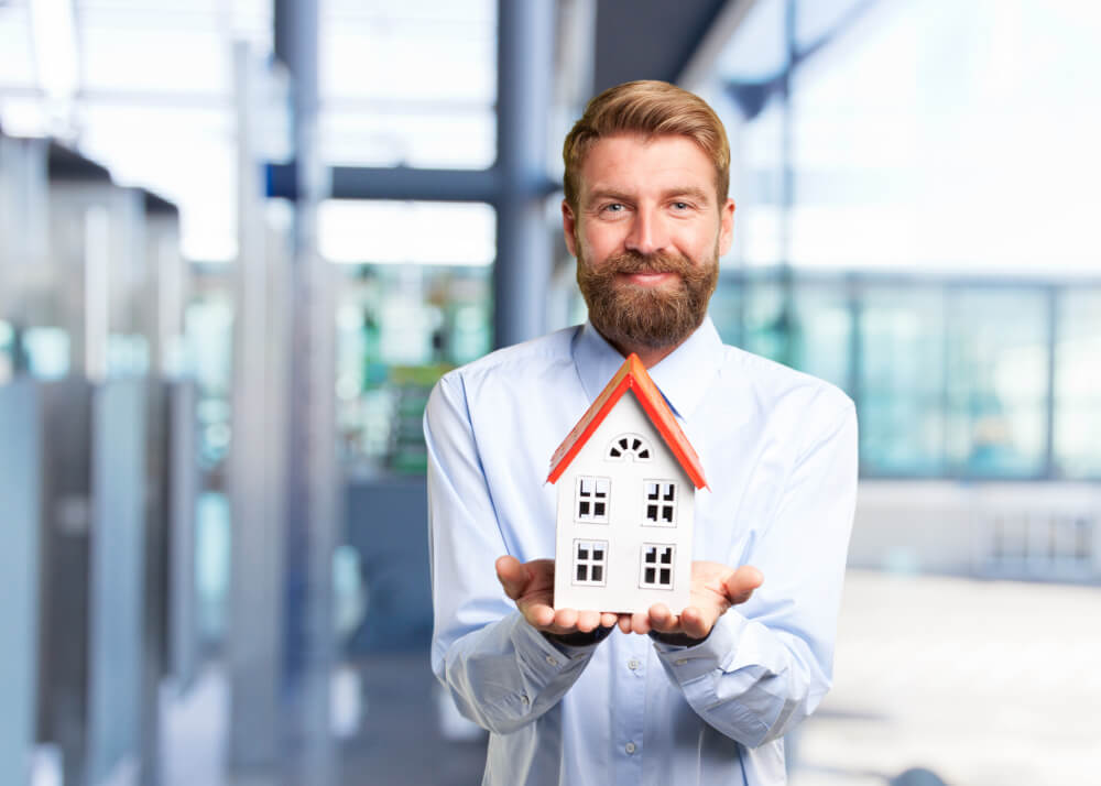real estate broker holding house model